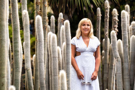 A girl in a white dress on the background of huge cacti on the island of Tenerife.Spain.の写真素材