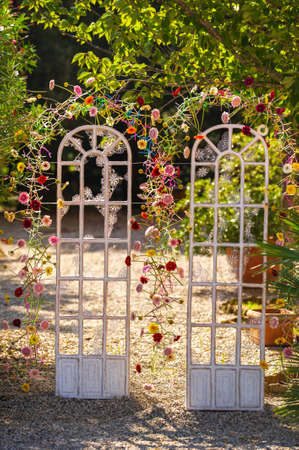 Arch for a wedding ceremony on the street .The decor is decorated with arches in the form of doors with fresh flowers.の写真素材