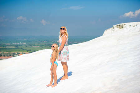 a little girl and her mother walk on the White Mountain in the city of Pamukkale. Turkey.の写真素材