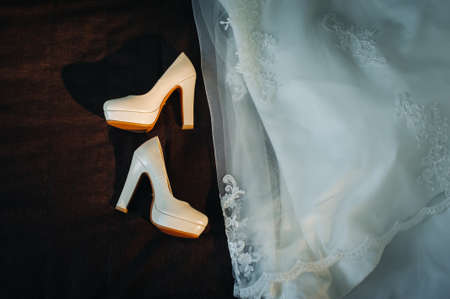 white wedding shoes and dress on black background.の写真素材