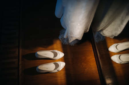 white wedding shoes standing on the field near the dress.の写真素材
