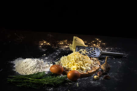 preparation of the process of cooking cheese balls with garlic and dill on a black background.の写真素材