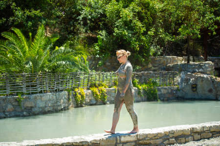 A girl walks along a pool with mud baths at a resort in Turkey.Health improvement in therapeutic mud.の写真素材