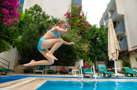 A girl in a blue swimsuit jumps into the pool. Marmaris, Turkeyの写真素材