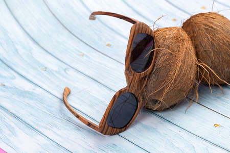 whole coconuts and wooden glasses on a blue wooden background.の写真素材