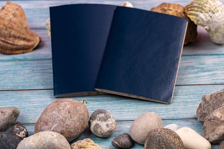 Documents, stones and shells on a blue wooden background.Travel theme.
