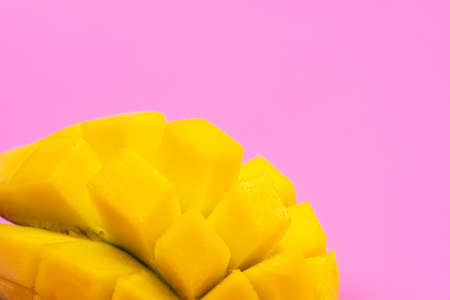 Fresh ripe mango on a pink background. Half a sliced mango on a pink background.の写真素材