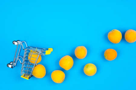 Shopping basket with apricots on a blue background.の写真素材