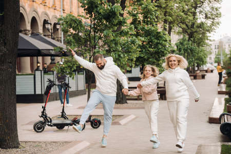 A happy family in white clothes walks around the city.の写真素材