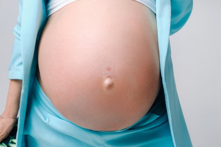 pregnant woman in a suit close-up on a gray background