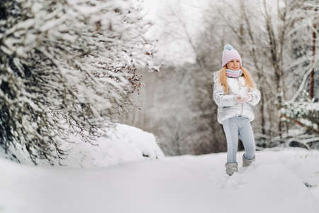 a little girl in a silver jacket in winter goes outside in winter.の写真素材
