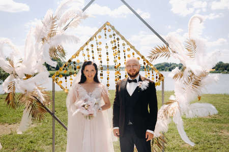 happy wedding couple near the arch during the wedding ceremony.の写真素材