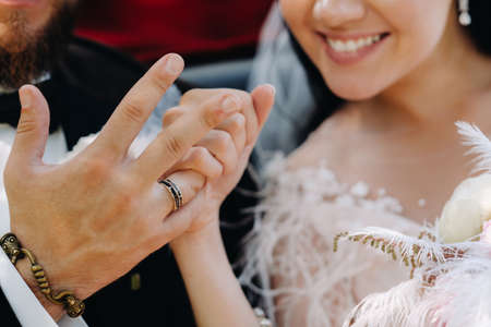 Close-up of the palms of the bride and groom with wedding rings on their hands.の写真素材