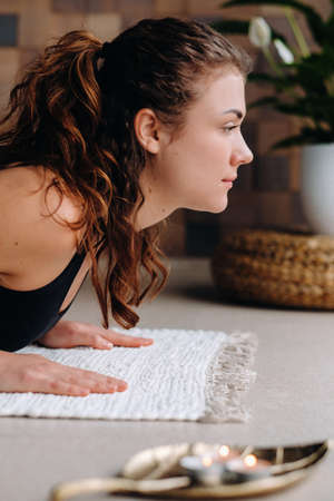A young woman in black clothes is doing yoga in a modern gym.の写真素材