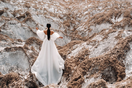 A beautiful unrecognizable bride in a wedding dress on top of the salty mountains. The wedding day. Beautiful portrait of the bride without the groom.の写真素材