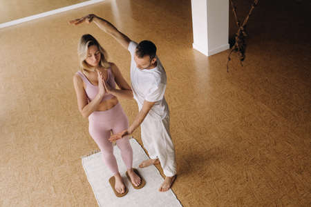 a man and a woman do yoga on boards with nails in the gym.