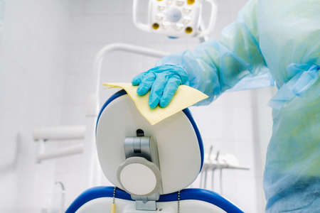 A nurse disinfects work surfaces in the dentist's office..