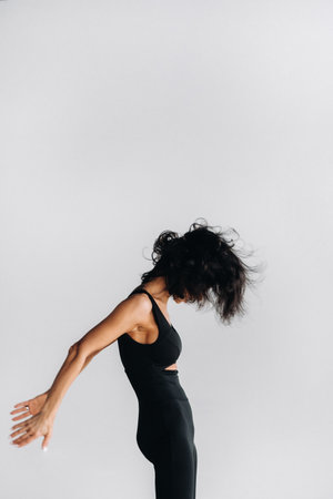 A woman in black sportswear is engaged in dynamic kali meditation in the Yoga hall.の写真素材