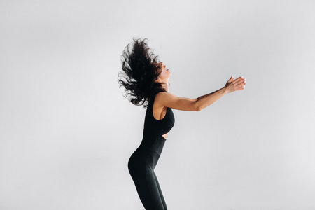 A woman in black sportswear is engaged in dynamic kali meditation in the Yoga hall.の写真素材