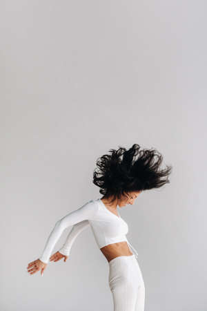 A woman in white sportswear is engaged in dynamic kali meditation in the yoga hall.の写真素材
