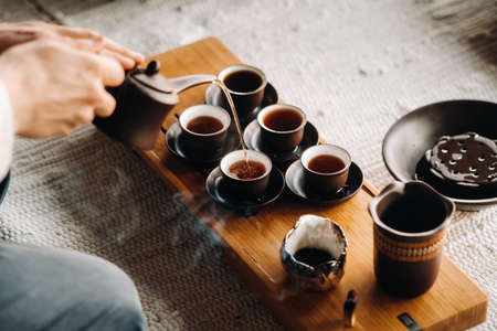 Close-up of pouring tea for a tea ceremony in a large company.の写真素材