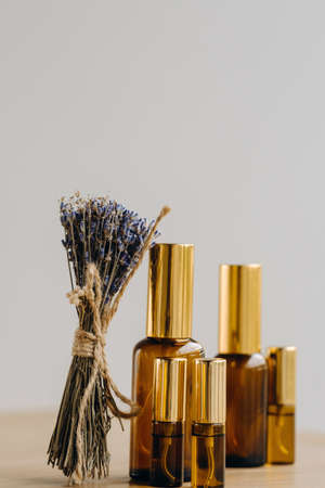 Essential oil in one bottle and dried lavender standing on the surface.の写真素材