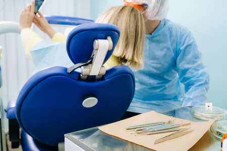 a dentist in a protective mask sits next to a patient and takes a selfie photo while working.の写真素材