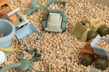 A modern children's sandbox with toys. Sandbox filler in the form of wooden small wooden cubes.