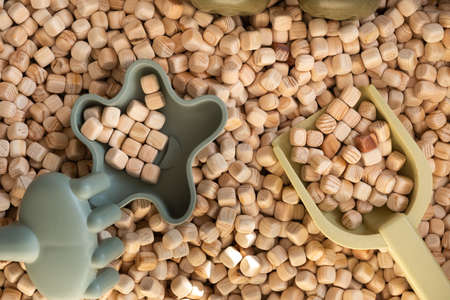 A modern childrens sandbox with toys. Sandbox filler in the form of wooden small wooden cubes