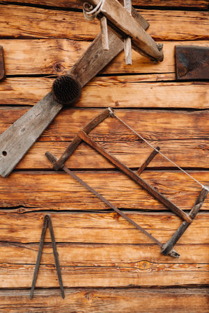 Old wooden wall of a house in the village and tools on the wall.