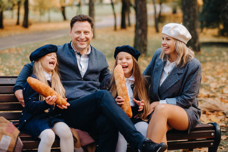 A large family is sitting on a bench in an autumn park. Happy people in the autumn park