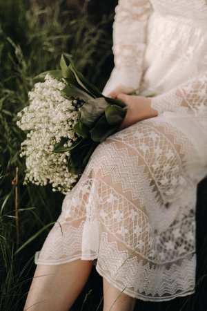 Close-up of lilies of the valley holding in the hands of a girl. Spring flowersの写真素材