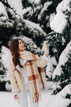 Portrait of a girl with long hair in mittens in a winter forest . Snowy winterの写真素材