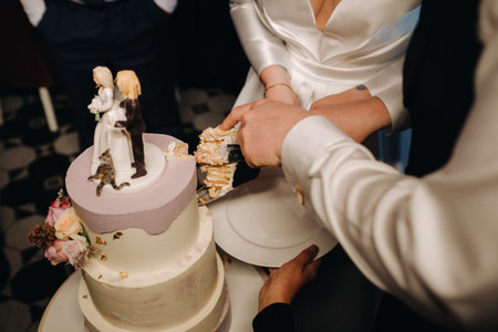 Three-level wedding cake with figures of people on it.