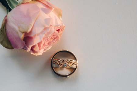 Designer wedding rings lying on the surface with a rose. Two wedding rings.