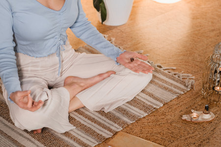 A young woman sitting in the Lotus position before the Game was playing and holding game cubes in her hand.の写真素材