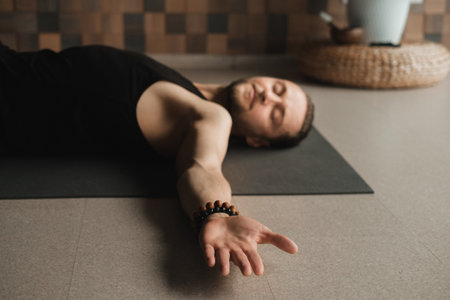 A man performing gymnastic exercises on a yoga mat at home.の写真素材