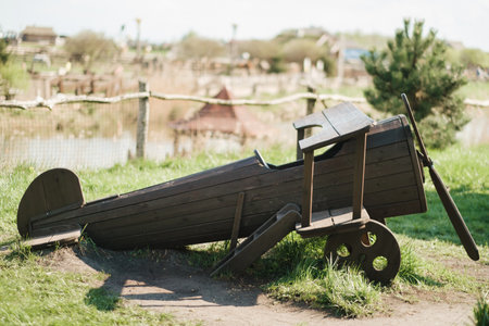 A wooden model of an airplane standing on the street in summer.の写真素材