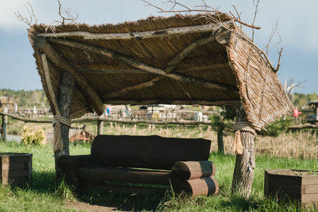 An old wooden gazebo for relaxing in the park. Equipped with wooden tables and benches.の写真素材