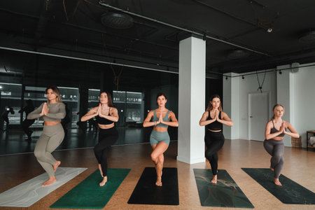 A group of beautiful girls are doing yoga in the fitness room. The concept of a healthy lifestyleの写真素材