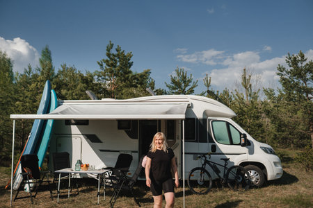 A happy tourist in her motorhome in nature.