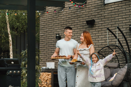 A happy family has prepared lunch and will eat at their house. Portrait of a family with food in...