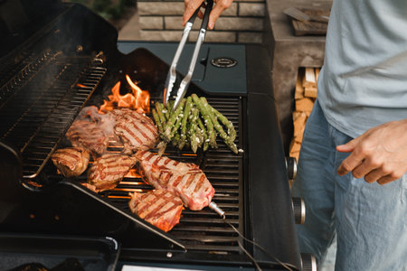 Cooking meat and vegetables on an outdoor grill.