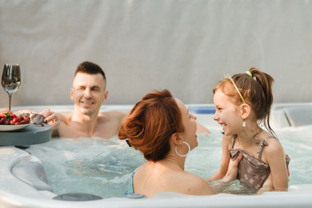 In summer, the family rests in the outdoor hot tub.の写真素材