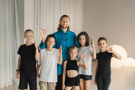 A joint portrait of a yoga coach and children standing in a fitness room.の写真素材