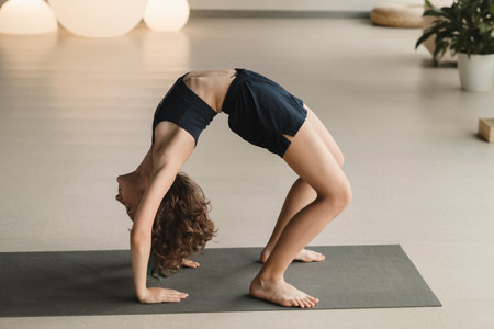 A child practices yoga poses indoors. Children's yoga.の写真素材