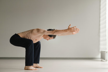 a man with a naked torso does yoga in the gym. the concept of a healthy lifestyle.の写真素材
