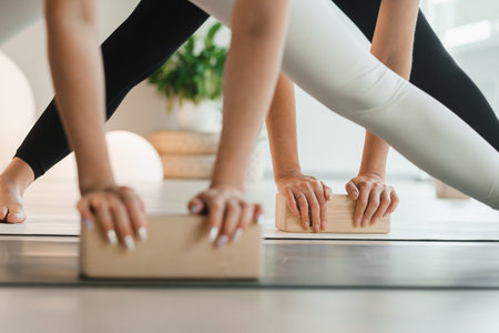 Close-up of female hands and feet practicing yoga using yoga blocks to support their body. Women's Health.の写真素材