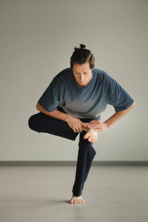 a man in a sports uniform does yoga in a fitness room. the concept of a healthy lifestyle.