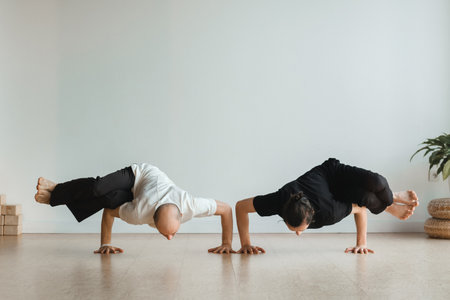 two young athletes practice yoga in the gym. Joint training, indoors, studio. The concept of a...